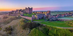 Northumbria Prints: UK, England, Northumberland, Bamburgh, Bamburgh Beach, Bamburgh Castle at sunrise