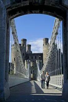 UK, North Wales; Conwy. Couple on the elegant Suspension Bridge built by Thomas Telford across the Conwy River to