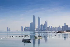 Images Dated 8th May 2014: United Arab Emirates, Abu Dhabi, View of City skyline reflecting in Persian Gulf