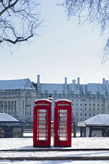 United Kingdom, England, London, red phone boxes on Victoria Embankment in the snow