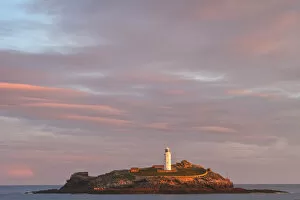 United Kingdom, UK, Cornwall, Sunrise colours and rainbow over Godrevy Lighthouse