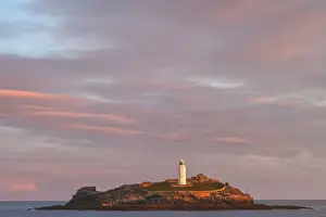 United Kingdom, UK, Cornwall, Sunrise colours and rainbow over Godrevy Lighthouse