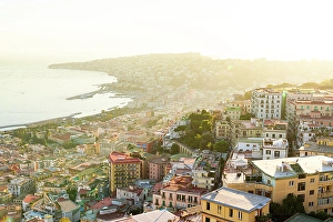 Crowded Prints: Urban skyline and coastline at sunset view from Vomero hill, Naples, Italy