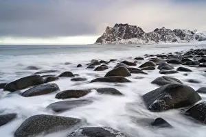 Uttakleiv Beach, with rocks in the fore and mountains in the background