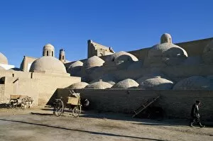 Central Asian Gallery: An Uzbek man walks beside the many domed walls of the Ichan Kala
