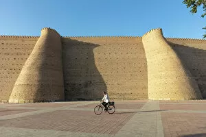 Images Dated 29th November 2022: Uzbekistan, Bukhara, UNESCO world heritage site, Ark Fortress, a man cycles past the city walls