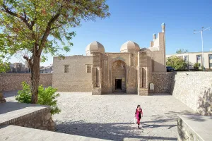 Silk Route Prints: Uzbekistan, Bukhara, a woman walks past a small mosque in central Bukhara