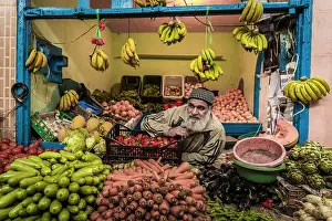 Stall Prints: Vendor at fruit and vegetable stall in market in the medina (old city), Essaouira, Morocco