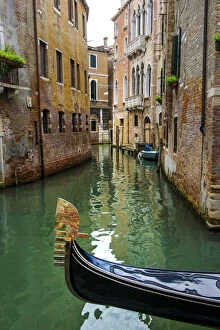 Venice, Veneto, Italy. Gondola sailing through a street canal