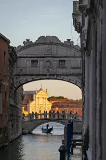 Images Dated 25th May 2022: Venice, Veneto, Italy. Gondolier under bridge of Sighs and St George church illuminated at sunset