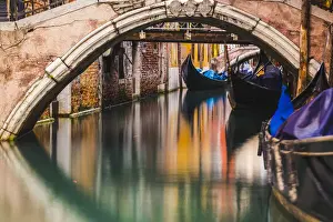 Stone Bridge Prints: Venice, Veneto, Italy. Moored gondolas under stone bridges