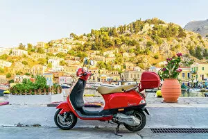 Images Dated 10th January 2023: A vespa scooter by the colourful harbour in Symi, Dodecanese Islands, Greece