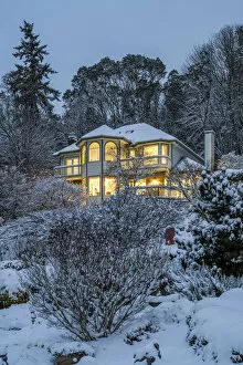 Victorian style lighted house framed in a snowy landscape, Bremerton, Washington, USA