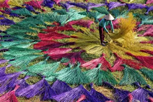 Factory Prints: Vietnam, Phu Yen province, a woman lays out traditional reed mats to dry