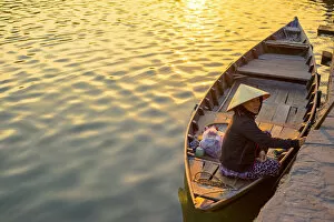 Vietnamese woman in a boat on the Thu Bon River at sunset, Hoi An, Quang Nam Province