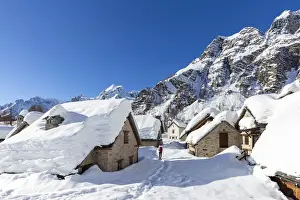 Trekker Prints: View of mountain huts and the church of the small town of Crampiolo in winter