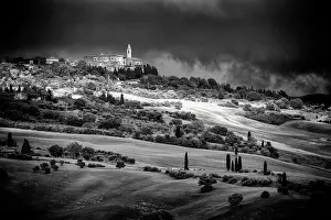 Pienza Prints: View across the Val d'Orcia towards Pienza beneath a dark, stormy sky, Tuscany, Italy