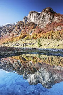 Transparent Prints: Village of Corte Terza and mountains is reflected in a clear puddle in autumn