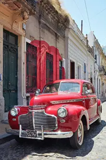 Automobile Prints: A vintage Chevrolet Master Deluxe car in front of a colonial house in San Telmo