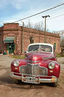 A vintage Chrysler car in front of a historical building of the Uribelarrea town, Buenos Aires province, Argentina