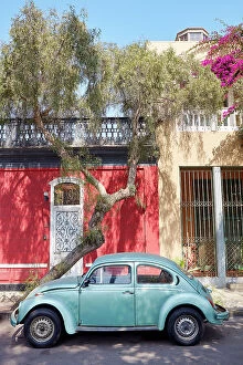 A vintage Volkswagen beetle car in front of a colonial house in Barranco, Lima, Peru