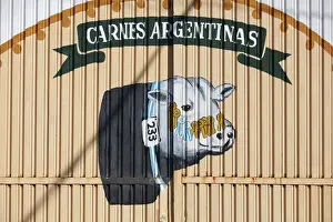 Street Art Prints: A wall art of an Argentine cow painted on the door of a building in Puerto Iguazu