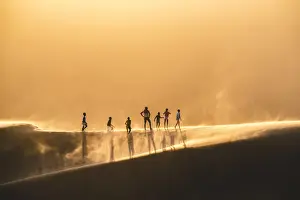 Dune Prints: Walvis Bay, Namibia, Africa. People walking on the edge of a sand dune at sunset