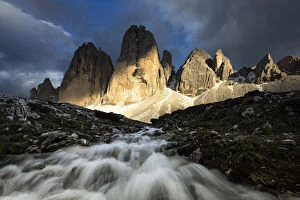 Warm Light Gallery: a warm light filters through the clouds and envelops the Tre Cime di Lavaredo during a