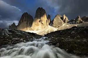 Summer Colours Prints: a warm light filters through the clouds and envelops the Tre Cime di Lavaredo during a