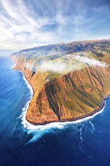 Breaking Wave Prints: Waves crashing on the majestic Ponta do Pargo cliffs at sunset, aerial view, Calheta