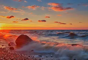 Waves crashing against the rocky shoreline of Lake Winnipeg at sunset Hillside Beach, Manitoba, Canada