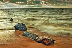 Waves crashing against the rocky shoreline of Lake Winnipeg at sunset Hillside Beach, Manitoba, Canada