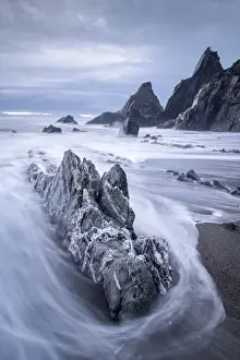 Stormy Evening Prints: Waves sweep onto the rocky beach on a stormy evening at Westcombe Bay, Devon, England
