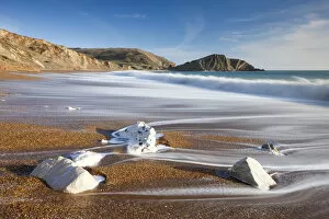 Waves wash clean the beautiful beach at Worbarrow Bay on the Jurassic Coast, Dorset