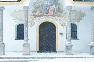The white facade of Heiligwasser Church on a snowy day, Igls, Innsbruck, Tyrol, Austria