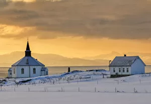 The white wooden octagonal church of Dverberg in the cold morning snowy landscape
