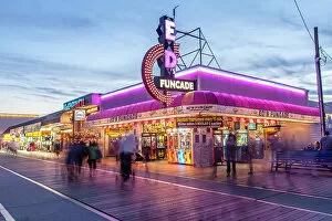 Images Dated 8th August 2022: Wildwood, New Jersey. Illuminated stores along the boadwalk at dusk. The Wildwood beach