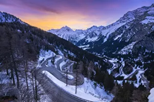 The winding curves of Maloja Pass road in winter at sunset, Bregaglia Valley, canton of Graubünden, Engadin, Switzerland