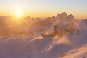 Larix Prints: a windstorm lifts the snow in a cold winter sunrise at the Lagazuoi refuge