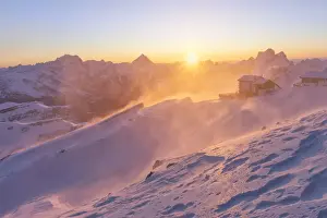 a windstorm lifts the snow in a cold winter sunrise at the Lagazuoi refuge