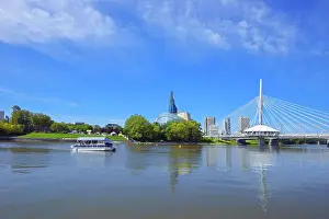 Winnipeg skyline with Canadian Museum for Human Rights and Esplanade Riel bridge with tour boat on the Red River, Winnipeg, Manitoba, Canada