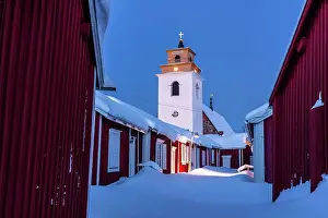 Snowdrift Prints: Winter dusk over the old bell tower and wood cottages covered with snow
