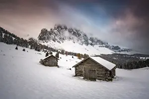 Funes Prints: Winter scenery with two wooden lodges and Odle Dolomites covered in snow. Malga Gampen