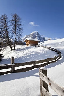 Winter snow covered mountain hut in front of Sassolungo mountain (3181m), Val Gardena