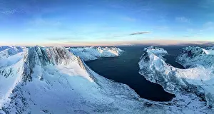 Time Of Day Prints: Winter sunrise over Breidtinden mountain covered with snow overlooking the cold sea