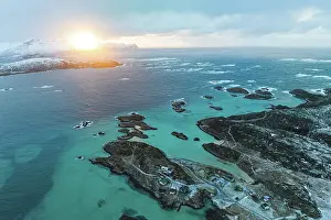 High Up Prints: Winter sunrise over the cold arctic sea and fishing huts on frozen cliffs