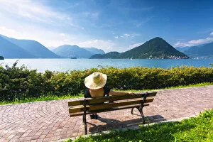 Woman on the bench in Iseo lake, Lombardy district, Brescia province, Italy. (MR)