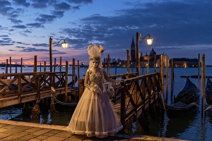 Mediterrranean Prints: A woman in costume stands by the lagoon during the Venice Carnival, Venice, Italy