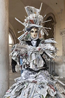 Images Dated 17th March 2020: A woman covered in newspaper walks through St. Mark