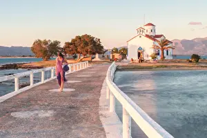 Orthodox Prints: A woman crossing the bridge that link Elafonissos island with the orthodox church of St